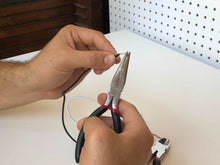 144 Piece Household Tool Kit with 4.8V Cordless Screwdriver - DT8422 pliers shown in use on an electrical wire