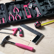 Apollo Tools 71 Piece Household Tool Kit Pink -model  DT0204P shows partial product and partial open case, hammer, saw, tape measure and square on the forefront