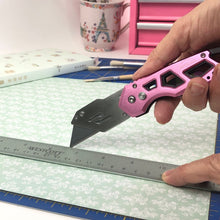 APOLLO TOOLS Ergonomic  Pink Utility Knife with Carabiner Clip and Fast-Change Blade - DT5017P shows product cutting paper