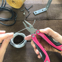 Apollo Tools 14-in-1 Pink High-Quality Pocket Multitool Pliers shown in use cutting wire