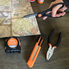 Apollo Tools 39 piece tool set DT9706OR (orange) shows scissors in use and other tools such as tape measure, utility knife and pliers on foreground